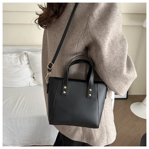 Model view of black retro tote bag with gold hardware and adjustable strap for daily commute