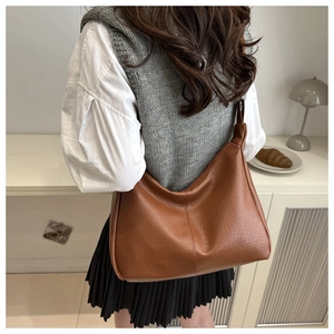 Detail of soft brown pebble leather Hobo bag worn over the shoulder for commute