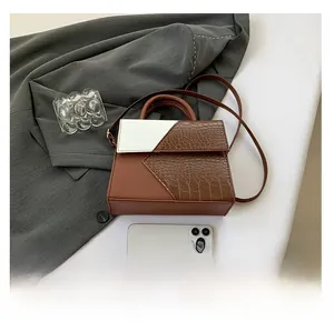 Detail of color-block tote bag with crocodile pattern and phone for size reference