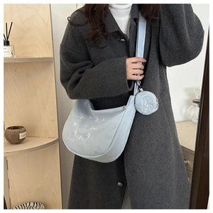 Détail du sac hobo en velours côtelé bleu clair avec porte-monnaie et broderie