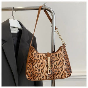 Detail of leopard print underarm bag with gold chain strap and metallic buckle