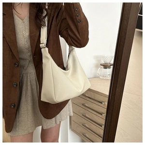 Detail of off-white lychee leather hobo bag with adjustable silver metal buckle side strap