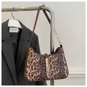 Detailed view of leopard print shoulder bag with gold metal buckle and leather strap