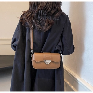 Vue détaillée du sac bandoulière marron avec fermoir métallique triangle argenté et sangle