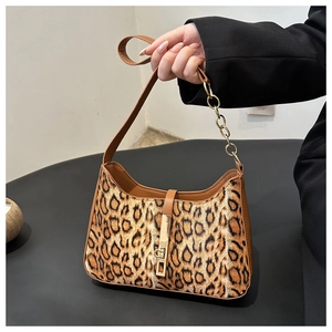 Detail of leopard print underarm bag featuring a gold chain and metal buckle closure