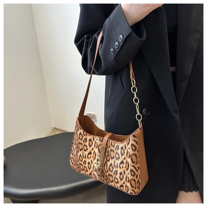 Detail of leopard print underarm bag featuring gold chain strap and metallic clasp