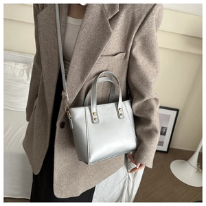 Detail view of silver matte tote bag with gold rivets and adjustable shoulder strap