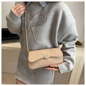 Detail of light apricot square bag with gold woven buckle and slim leather strap