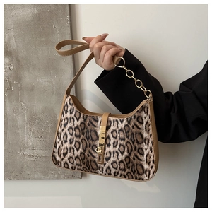 Detail of leopard print shoulder bag featuring gold chain strap and metal buckle closure