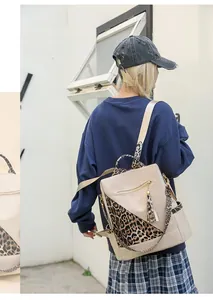 Detail of stylish leopard print backpack with decorative tassels and side pocket in outdoor setting