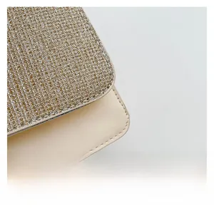 Gros plan sur la texture tissée métallique et le cuir beige lisse d'un petit sac carré chic