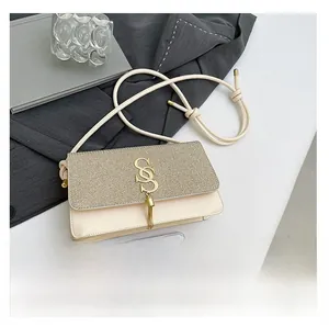 Détail du sac crème avec rabat à paillettes dorées et fermoir en S métallique chic