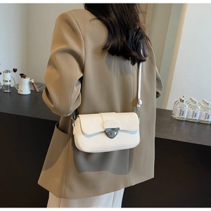 Vue détaillée d'un sac bandoulière blanc avec fermoir argenté porté par un mannequin
