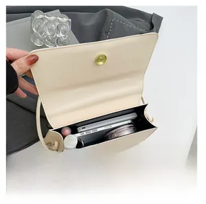 Vue détaillée de l'intérieur du sac crème avec fermoir doré et compartiments pour mobile