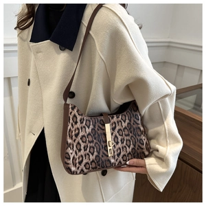 Detail of leopard print shoulder bag featuring metal buckle and brown leather strap