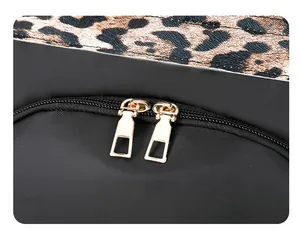 Macro shot of gold dual metal zippers on black travel backpack with leopard print detail