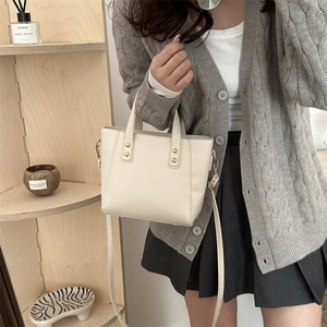 Creamy white vintage tote bag with gold rivets and detachable strap shown in 45-degree angle