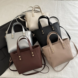 Minimalist leather tote bags in five colors with top handles and adjustable shoulder straps