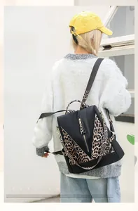 Detail view of fashion leopard print backpack with gold zippers and anti-theft design