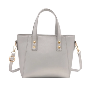 Minimalist light grey faux leather tote bag with gold rivets for office commuting