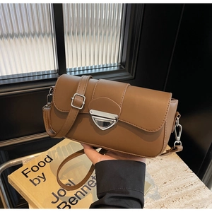 Détail d'un sac bandoulière marron en cuir PU avec boucle argentée et rabat rectangulaire