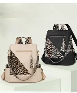 Detail of leopard print nylon backpacks in beige and black with anti-theft back opening