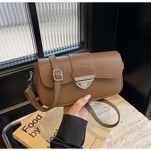 Détail du petit sac bandoulière vintage en cuir marron avec boucle écusson argentée