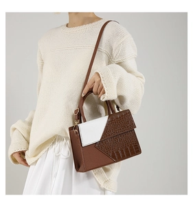 Detail of crocodile pattern crossbody bag with brown and white color-block finish