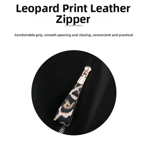 Detail of leopard print leather zipper puller with premium gold metal hardware on black bag