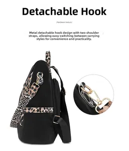 Detail of detachable gold-tone metal hooks on a black leopard print backpack strap