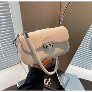 Détail d'un sac bandoulière blanc en cuir avec une boucle métallique triangulaire argentée