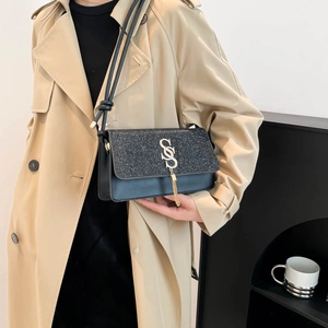 Petit sac à bandoulière noir minimaliste avec rabat pailleté et logo doré à frange