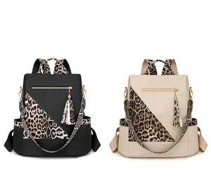 Detail of travel backpacks in black and beige with leopard print straps and zipper tassels