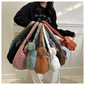 Close-up of corduroy tote bags in multiple colors with matching alphabet coin purses
