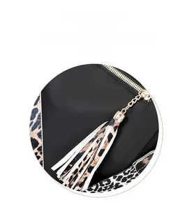 Detail of fashion backpack featuring leopard print tassel zipper and gold metal hardware