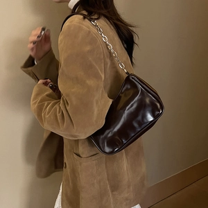 Detail view of dark brown glossy underarm bag with stylish silver metal chain strap