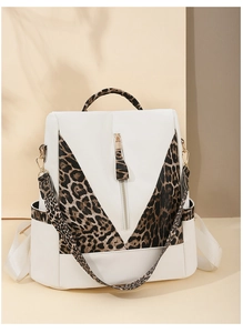 Detail of leopard print stitching and golden hardware on a white leather backpack