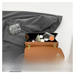 Internal capacity of two-tone leather bag showing phone and cosmetics inside