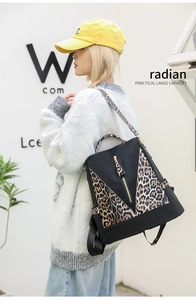 Close-up of leopard print panels and golden zipper on black large capacity backpack