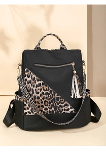 Detail view of water-resistant nylon backpack with leopard print accents and tassel