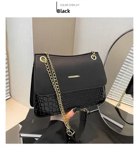 Detail of black faux leather handbag featuring matte texture and glossy crocodile pattern