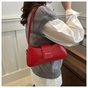 Glossy red baguette bag featuring a thin shoulder strap and polished leather texture