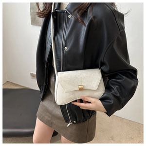 Vue détaillée d'un sac à main blanc motif crocodile avec une boucle en métal doré chic