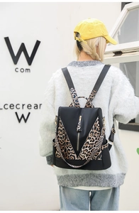 Detail of leopard print backpack with gold zippers and durable nylon material