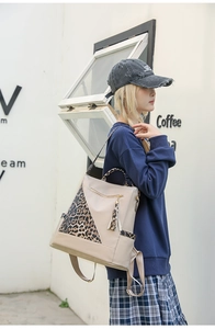 Close-up of stylish beige backpack with leopard print details and elegant metal zippers
