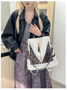 Close-up of leopard print patchwork backpack with gold buckles and white leather detailing