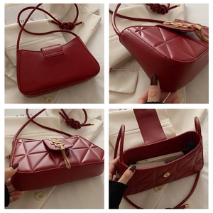 Detailed view of burgundy quilted shoulder bag with gold tassel and knotted strap