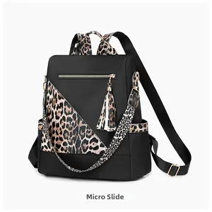 Detailed side view of nylon backpack featuring leopard print trim and tassel charms