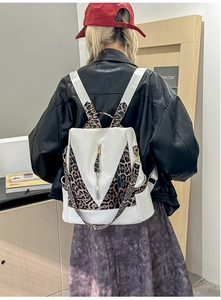 Detailed view of leopard print backpack with gold zipper and stylish PU leather patchwork