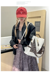 Detail of white backpack with leopard print straps worn by a model in casual attire